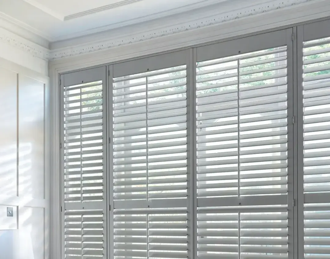Full height white plantation shutters covering a full window for privacy and light control